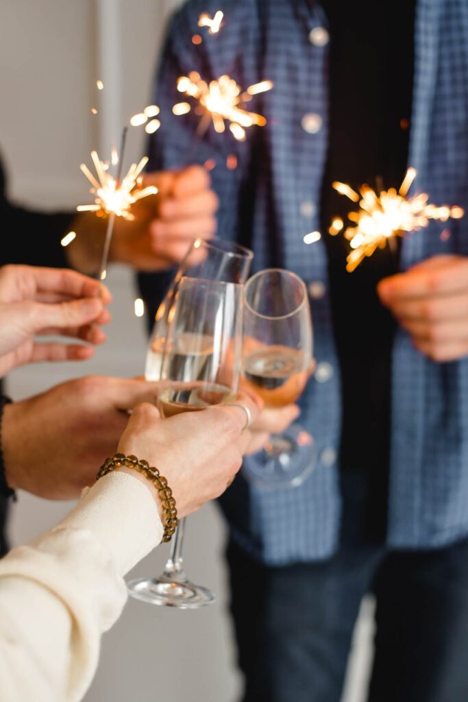 Grupo de amigos celebrando y brindando con copas de vino blanco sin alcohol