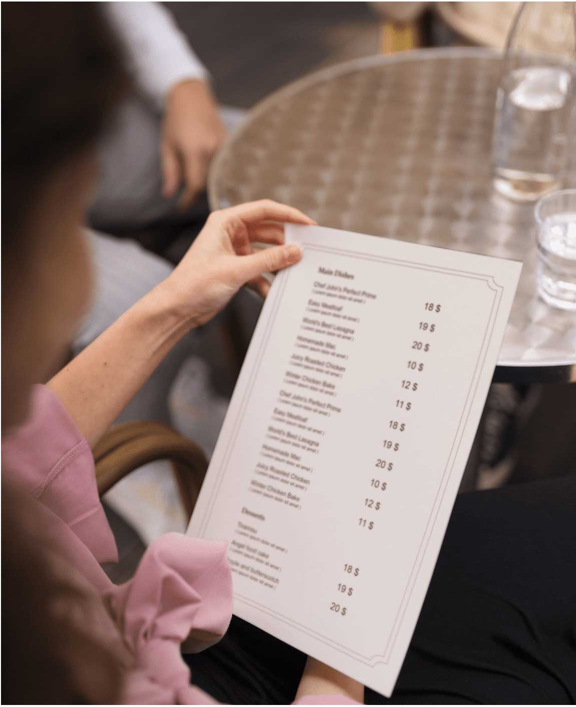 Mujer en una terraza de un restaurante mirando la carta de vinos sin alcohol.