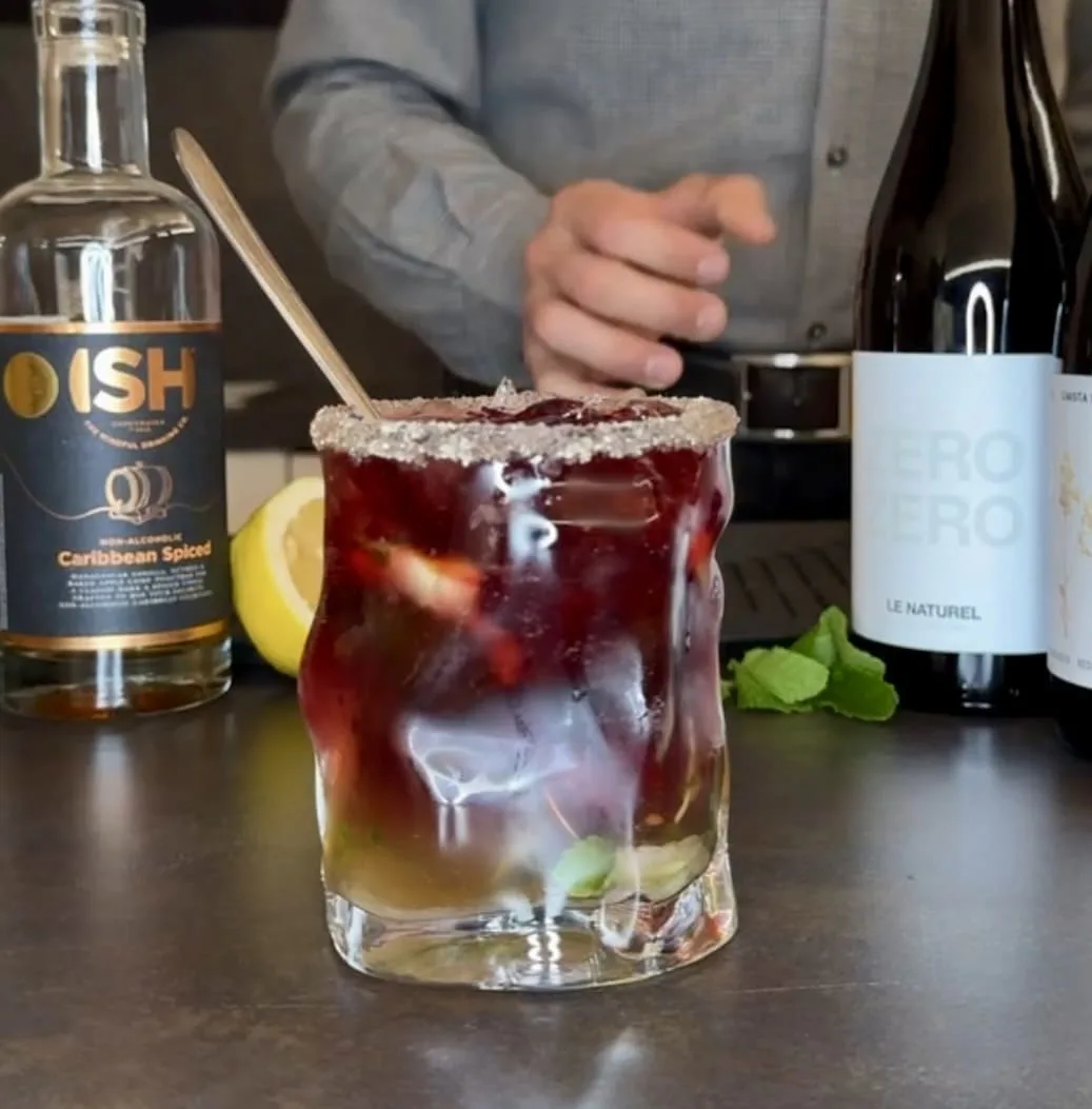 Cócteles sin alcohol coctel de vino tinto en una mesa de bar con botellas de licor sin alcohol y vino sin alcohol al lado
